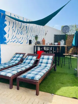 two benches sitting on the grass under a tent at Villa with rooftop bar overlooking sea, pool & vegetable garden in Tamaris
