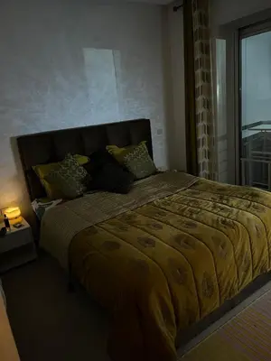 a bedroom with a large bed with a yellow blanket at Villa with rooftop bar overlooking sea, pool & vegetable garden in Tamaris