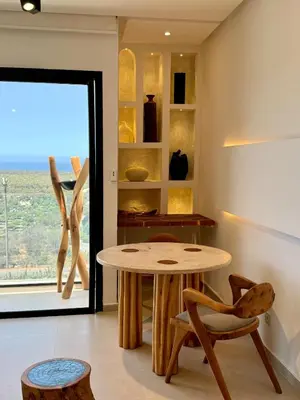 a table and chairs in a room with a window at Unique apartment in Prestigia Hay Riad Rabat in Rabat