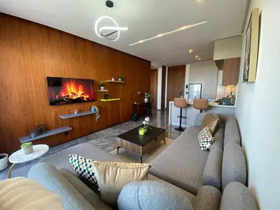 a living room with a couch and a fireplace at Central Luxury Apartment with Fast Fiber WiFi, Panoramic Balcony & Free Parking in Casablanca CFC Casa Finnance City in Casablanca