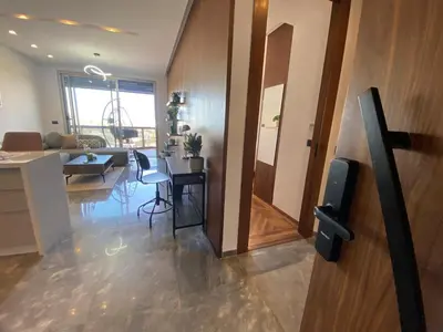 a living room with a television and a living room with a couch at Central Luxury Apartment with Fast Fiber WiFi, Panoramic Balcony & Free Parking in Casablanca CFC Casa Finnance City in Casablanca