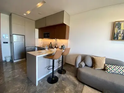 a kitchen and a living room with a couch at Central Luxury Apartment with Fast Fiber WiFi, Panoramic Balcony & Free Parking in Casablanca CFC Casa Finnance City in Casablanca
