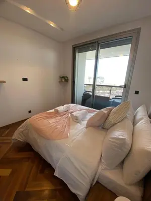a large bed in a room with a couch at Central Luxury Apartment with Fast Fiber WiFi, Panoramic Balcony & Free Parking in Casablanca CFC Casa Finnance City in Casablanca