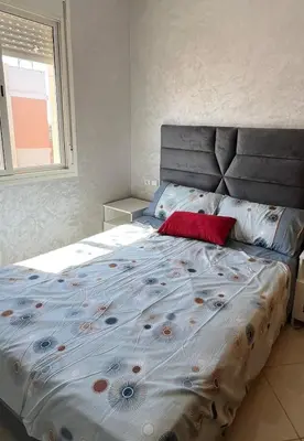 a bed with a red pillow on it in a bedroom at Chic, quiet and convenient apartment in Casablanca