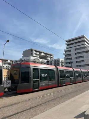 a red train traveling down a street with buildings at Appartement Casa finance city Studio Haut standing in Casablanca