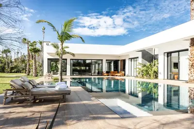 an exterior view of a house with a swimming pool at Villa l'Hermitage in Oulad Mbark