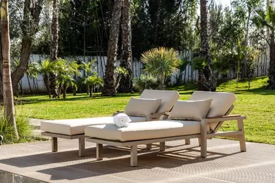 a group of lounge chairs and tables in a park at Villa l'Hermitage in Oulad Mbark