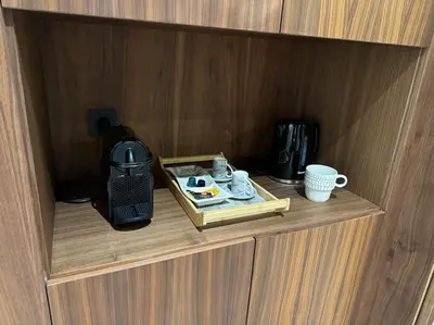 a wooden cupboard with a coffee maker and a coffee pot and a mug at Studio Chic Princesses Maarif - Wifi haut débit in Casablanca