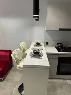 a kitchen with a white counter and a red couch at Studio Chic Princesses Maarif - Wifi haut débit in Casablanca