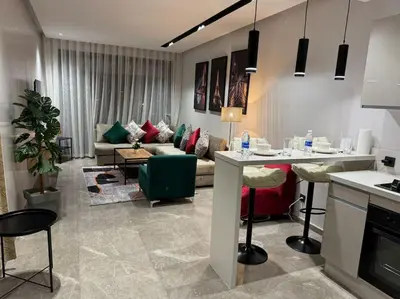 a living room with a couch and a table at Studio Chic Princesses Maarif - Wifi haut débit in Casablanca