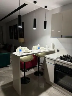 a kitchen with a counter with stools and a stove at Studio Chic Princesses Maarif - Wifi haut débit in Casablanca