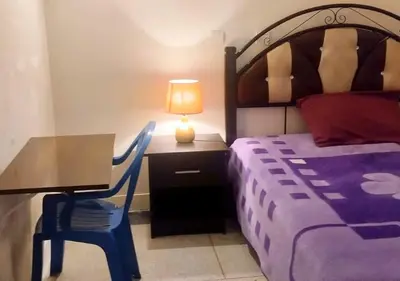 a bedroom with a bed and a table with a lamp at Comfortable Room 2 at Homestay Casablanca in Maarif