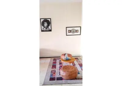 a living room with a table and a rug at Comfortable Room 2 at Homestay Casablanca in Maarif