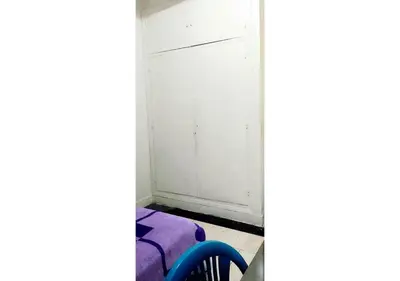a room with a white closet door and a blue chair at Comfortable Room 2 at Homestay Casablanca in Maarif