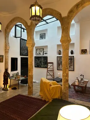 a living room with columns and a chandelier at Dar DIESUS NOOR in Azemmour