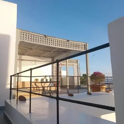 a patio with a table and chairs on a balcony at Dar DIESUS NOOR in Azemmour