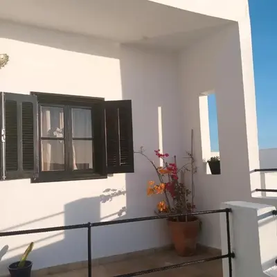 a balcony with a window and a potted plant at Dar DIESUS NOOR in Azemmour