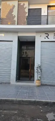 a building with two garage doors and a potted plant in front at Myhiven Immob in Casablanca