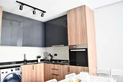 a kitchen with black cabinets and a washer and dryer at Myhiven Immob in Casablanca