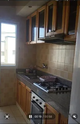 a kitchen with wooden cabinets and a stove top oven at Appartement à Casablanca in Casablanca