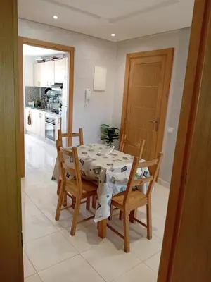 a kitchen and dining room with a table and chairs at Appartement Jad & Rim in Bouznika