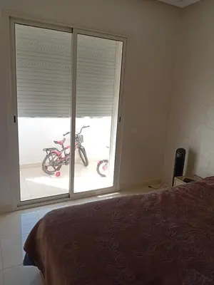 a bedroom with a bike outside of a window at Appartement Jad & Rim in Bouznika