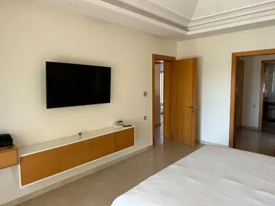 a bedroom with a flat screen tv on the wall at Bouznika Bay Villa Prestigious Oasis in Sidi el Haj Bou Derbala