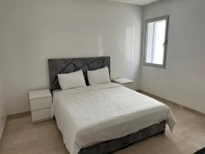 a white bedroom with a large bed and a window at Bouznika Bay Villa Prestigious Oasis in Sidi el Haj Bou Derbala