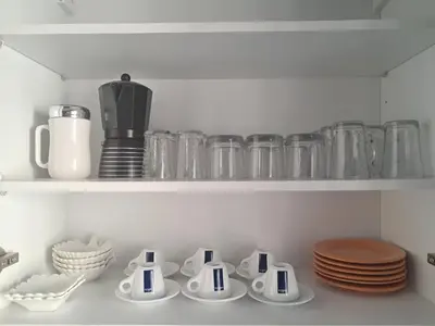 a shelf with dishes and glass jars and plates at L'appartement est situé au centre de Rabat in Rabat