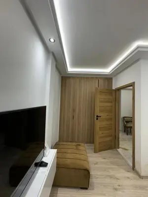 a room with a bed and a television and a door at Appartement VictoriaBouskoura in Casablanca