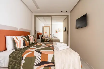 a bedroom with a bed and a tv on a wall at Modern & bright studio Balcony & Parking Maarif in Casablanca
