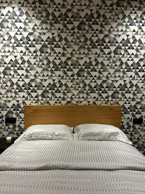 a bedroom with a bed with a geometric wallpaper at Maarif in Casablanca
