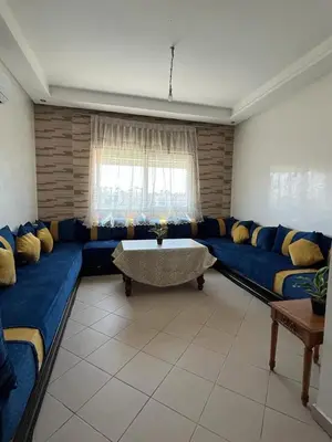 a living room with a blue couch and a table at Mansoria in Mansouria