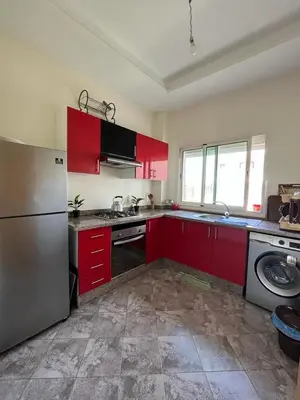a kitchen with red cabinets and a refrigerator at Mansoria in Mansouria