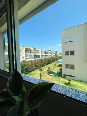 a plant in a window with a view of a building at Mansoria in Mansouria