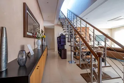 a lobby with a staircase and a room with flowers at Superb Villa in Bouznika with Private Pool & Hammam in Bouznika