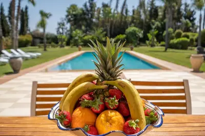 a bowl of fruit sitting on a table next to a pool at Superb Villa in Bouznika with Private Pool & Hammam in Bouznika