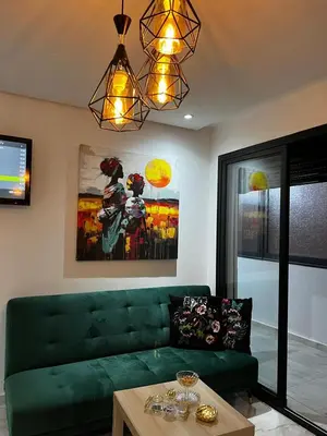 a living room with a green couch and a table at Skyline Urban - by Nero in Casablanca