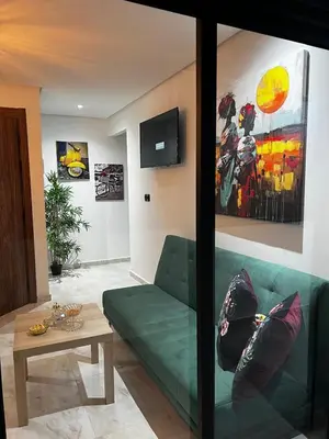 a living room with a green couch and a table at Skyline Urban - by Nero in Casablanca