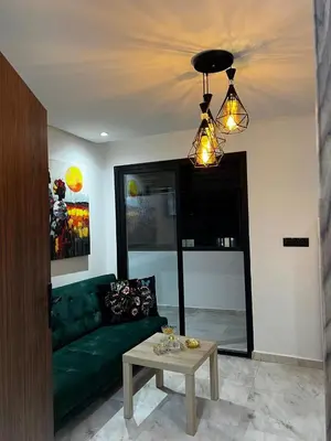 a living room with a green couch and a table at Skyline Urban - by Nero in Casablanca