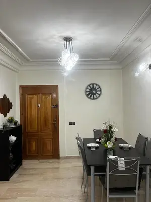 a dining room with a table and a clock on the wall at Zen Haven - by Nero in Casablanca
