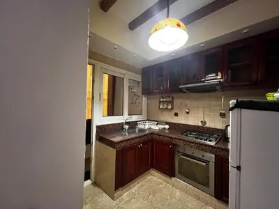 a kitchen with wooden cabinets and a light on the ceiling at Pure Space - by Nero in Casablanca