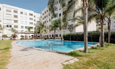 a swimming pool in front of a building at Comfort Stay by Mohammed V Airport in Nouaseur
