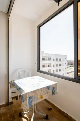 a table in a room with a large window at Comfort Stay by Mohammed V Airport in Nouaseur
