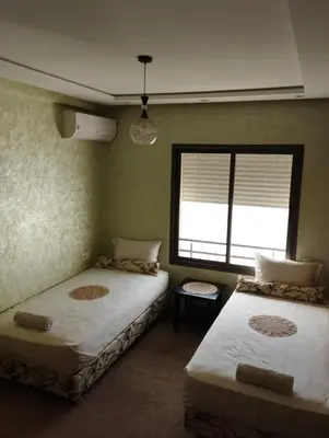 two beds in a room with a window at Comfort Stay by Mohammed V Airport in Nouaseur
