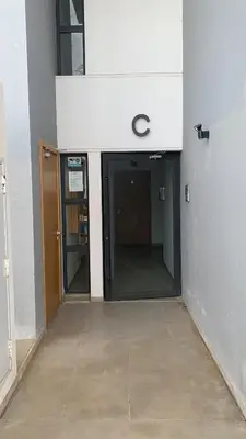 an empty hallway of an office building with a door at Appartement avec une Chambre, Salon, Salle de Bain et Piscine in El Harhoura