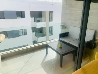 a living room with a chair and a table at Appartement avec une Chambre, Salon, Salle de Bain et Piscine in El Harhoura