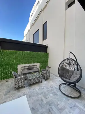 a patio with a rattan chair and a bench at Appart youssef in Casablanca