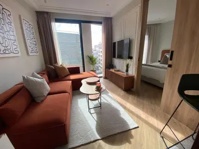 a living room with a couch and a tv and a bed at Studio moderne rooftop et gym Triangle d or casablanca in Casablanca