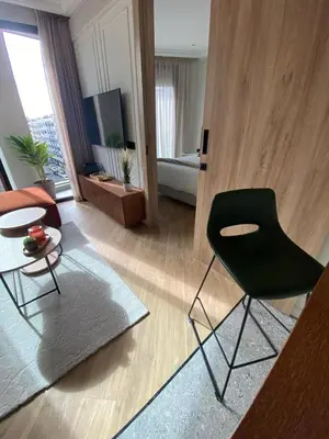 a living room with a black chair and a table at Studio moderne rooftop et gym Triangle d or casablanca in Casablanca